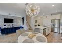 Stylish living room featuring a large chandelier, modern furnishings, and an open floorplan to the kitchen at 25 Barbara Ln # 67, Las Vegas, NV 89183