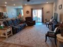 Open-concept living room with cozy furniture, carpet flooring, and a sliding glass door leading to the patio at 3862 E Summit Ave, Pahrump, NV 89061