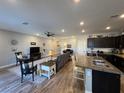 Open concept living room and kitchen with dark cabinets and stainless steel appliances at 3862 E Summit Ave, Pahrump, NV 89061