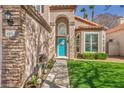 Charming home entrance with a bright blue front door and meticulously maintained landscaping at 4516 Whelk Pl, North Las Vegas, NV 89031