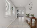 Bright hallway featuring neutral walls, tile flooring, large windows, and decorative furniture at 4733 Cactus Sun Ln, North Las Vegas, NV 89031