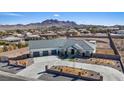 Wide shot of the home featuring a large three-car garage, long driveway and mountain views in the distance at 541 Patti Ann Woods Dr, Henderson, NV 89002