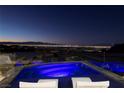 Rooftop pool and deck area with night view of city lights and mountain range at 667 Solitude Rock Ct, Henderson, NV 89012