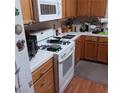 Modest kitchen featuring white appliances, wooden cabinets, and tile countertops at 6903 Wineberry Dr, Las Vegas, NV 89119