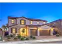 Beautiful two-story home featuring a brick driveway, a three-car garage, and manicured landscaping at 7411 Zonal Ave, Las Vegas, NV 89131