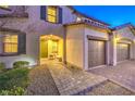 Inviting front entrance showcasing a paved walkway, green door, and three-car garage at 7411 Zonal Ave, Las Vegas, NV 89131