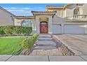 Inviting home entrance showcasing a well-kept lawn and a stone pathway leading to the front door at 7520 Cobal Canyon Ln, Las Vegas, NV 89129