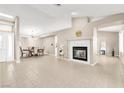 Open concept living room and dining area featuring tile floors, a fireplace, and modern lighting at 7624 Desert Delta Dr, Las Vegas, NV 89128