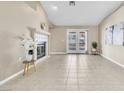 Bright living room featuring a fireplace, tile flooring, and French doors to outdoor space at 7624 Desert Delta Dr, Las Vegas, NV 89128