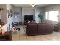 Cozy living room features neutral walls, large windows and comfortable furniture at 8494 Langhorne Creek St, Las Vegas, NV 89139