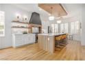 Bright kitchen featuring a large island, custom cabinetry, stainless steel appliances, and light wood floors at 10612 Back Plains Dr, Las Vegas, NV 89134