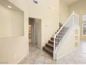 Bright foyer with tile flooring, staircase, neutral walls, and an arched niche for décor at 1123 Scenic Crest Dr, Henderson, NV 89052