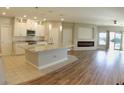 Open floor plan of the Kitchen showcasing a large granite island, a fireplace, and stainless steel appliances at 11260 Burning River St, Las Vegas, NV 89183