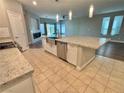 Gorgeous kitchen featuring a large granite island with a stainless steel sink, stainless steel appliances, and tile flooring at 11260 Burning River St, Las Vegas, NV 89183