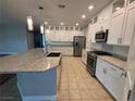 Bright kitchen featuring white cabinets, stainless steel appliances, and a granite island at 11260 Burning River St, Las Vegas, NV 89183