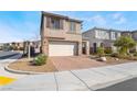 Two-story house with a two-car garage and a brick paver driveway in a desert landscaped yard at 1338 Ossa St, Henderson, NV 89052