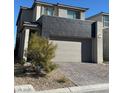 Modern two-story home featuring a two-car garage and brick paved driveway at 1586 Crowned Eagle St, Las Vegas, NV 89138