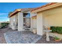 Inviting outdoor seating on brick-paved front porch with glass paneled door, complemented by a bird bath at 1800 Summit Pointe Dr, Las Vegas, NV 89117