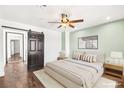 Comfortable bedroom with a ceiling fan, stylish artwork, and a sliding barn door to the closet at 2301 W El Camino Ave, Las Vegas, NV 89102