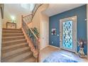 Inviting foyer with a staircase, tile flooring, and a stylish front door with stained glass window panes at 2375 Malaga Peak St, Las Vegas, NV 89135