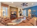 Comfortable living room boasts a fireplace, ceiling fan, and hardwood flooring, perfect for relaxing at 2375 Malaga Peak St, Las Vegas, NV 89135