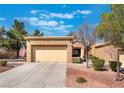 Charming tan single-story home featuring a two-car garage, desert landscaping, and a welcoming entrance at 2735 Faiss Dr, Las Vegas, NV 89134