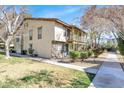 A two-story house has a balcony with trees beside the walkway with green grass yard and stone ground cover at 3157 Pinehurst Dr # B, Las Vegas, NV 89109