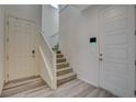 Bright foyer featuring wood-look flooring, staircase, and a white front door at 4115 Spring Storm Ave, North Las Vegas, NV 89081