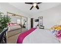 Cozy bedroom featuring a ceiling fan, mirrored closet doors, and neutral decor at 4557 Bersaglio St, Las Vegas, NV 89135