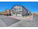 Street view of townhome with attached garages, manicured landscaping, and red-curbed road at 4640 Flower Moon Ave # 102, North Las Vegas, NV 89084