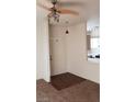 Apartment entryway with a ceiling fan and lighting, dark wood flooring and a glimpse of the kitchen at 5750 E Hacienda Ave # 202, Las Vegas, NV 89122