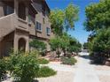 Landscaped apartment building with manicured bushes and trees along a sidewalk in a tidy neighborhood at 5750 E Hacienda Ave # 202, Las Vegas, NV 89122