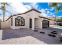 Well-maintained home with a gravel yard and a black door and garage door at 6505 Moon Roses Ct, Las Vegas, NV 89108