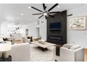 Bright and airy living room featuring a modern fireplace, large ceiling fan, and stylish decor at 6505 Moon Roses Ct, Las Vegas, NV 89108