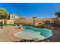 Backyard pool featuring a rock waterfall feature and surrounding stone patio at 74 Harbor Coast St, Las Vegas, NV 89148