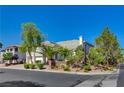 Two-story home with lush landscaping, including mature palm trees, offering great curb appeal at 7623 Calm Passage Ct, Las Vegas, NV 89139