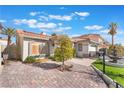 Charming single-story home with a well-manicured lawn, mature palm trees, and paver driveway at 8520 Copper Falls Ave, Las Vegas, NV 89129