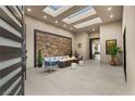 Cozy seating area with stone accent wall and multiple skylights at 9 Stonecutter Ct, Henderson, NV 89012