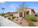 Inviting one-story home with a quaint front porch, desert landscaping, and two-car attached garage at 1009 Via Canale Dr, Henderson, NV 89011