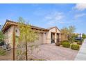 Single-story home with a two-car garage, a covered front porch and low-maintenance landscaping at 1009 Via Canale Dr, Henderson, NV 89011
