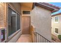 Close-up of apartment door with exterior light, window, and stucco siding at 3351 Indian Shadow St # 204, Las Vegas, NV 89129