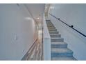 Bright hallway featuring a staircase with a gray carpet and black railing at 384 E Erin St # 3, Pahrump, NV 89048