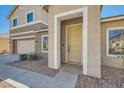 Inviting home entrance with a stylish front door, neutral paint, and manicured landscaping at 3925 Champagne Wood Dr, North Las Vegas, NV 89031