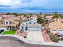 Stunning aerial view of a two-story home featuring a three-car garage, neat landscaping, and a long driveway at 511 Beaconwood St, Henderson, NV 89052