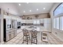 Well-lit kitchen boasting granite countertops, stainless steel appliances, and an island with bar stool seating at 511 Beaconwood St, Henderson, NV 89052