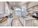 Bright kitchen with stainless steel sink, granite countertops, an island, and views of a dining and living area at 511 Beaconwood St, Henderson, NV 89052