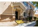 Exterior view of a home entrance featuring stairs with yellow accents and neutral stucco at 6493 Za Zu Pitts Ave # 101, Las Vegas, NV 89122