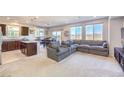 Spacious living room featuring neutral carpet, large windows, and a comfortable sectional sofa perfect for gatherings at 6637 Rockhouse St, North Las Vegas, NV 89086