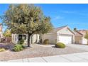 Well kept single story home with desert landscaping, mature tree, and two car garage at 7912 Purple Mountain Ave, Las Vegas, NV 89131