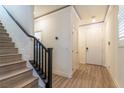 Inviting foyer featuring wood-look floors, staircase, and a white front door that offers a warm welcome at 8446 Vacarez Dr, Las Vegas, NV 89149